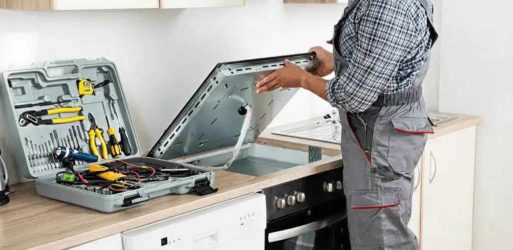 Handyman repairing a cooktop and checking wiring connections in Evansville, IN