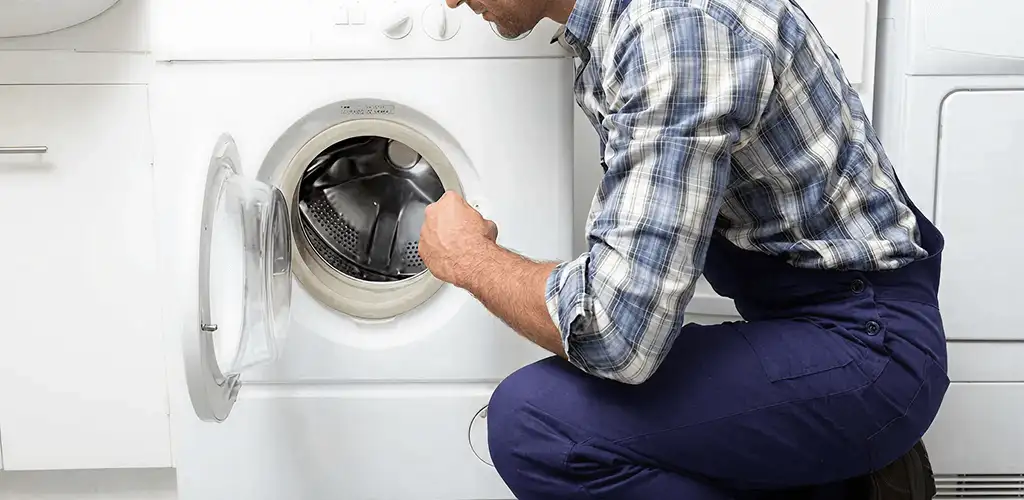 Handyman inspecting a dryer drum and internal parts for repair in Evansville, IN
