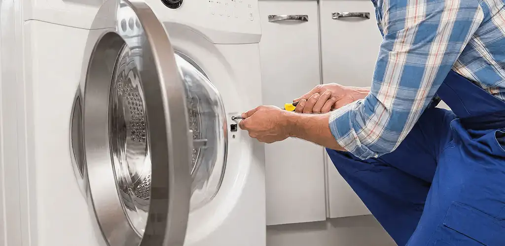 Handyman repairing a clothes dryer and checking electrical connections in Evansville, IN