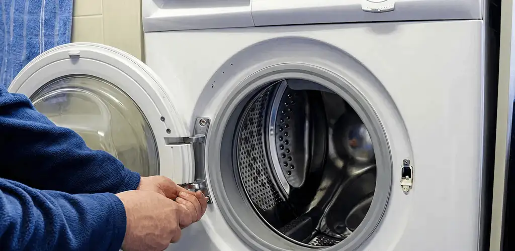 Washing machine repair handyman checking a front-load washer door and latch in Evansville, IN