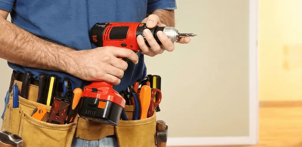 Handyman holding a power drill for home repairs and installations in Evansville, IN