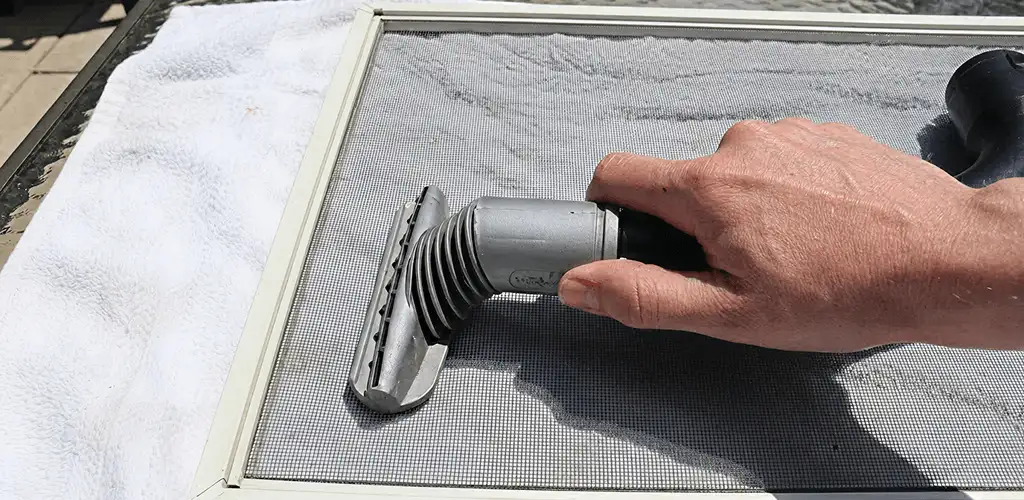 Window screen repair cleaning and fixing a damaged screen mesh in Evansville, IN